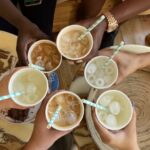 A group of international friends raising mugs in celebration during a coffee meetup in Cyprus