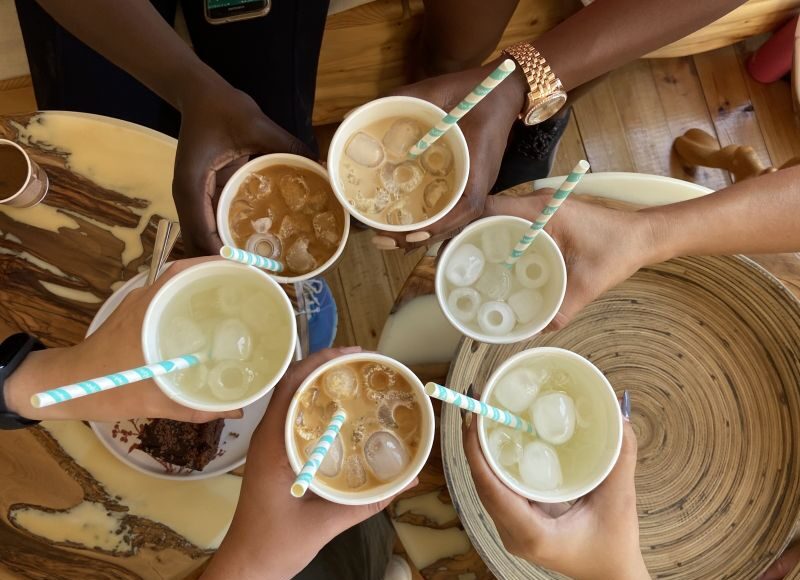 A group of international friends raising mugs in celebration during a coffee meetup in Cyprus
