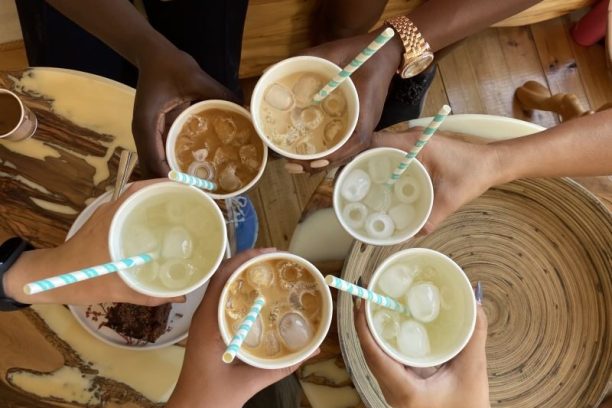 A group of international friends raising mugs in celebration during a coffee meetup in Cyprus